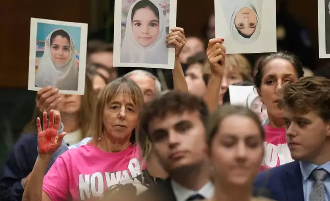 Code Pink co-founder Medea Benjamin, left, listens as Defense Secretary Pete Hegseth testifies at a Senate Appropriations Committee hearing, Tuesday, July 21, 2026, on Capitol Hill in Washington. (AP Photo/Jacquelyn Martin)