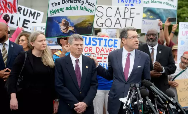 Former Olympic canoeist David Hearn, second from left, listens as his attorney Norman Eisen, right, speaks after he pleaded not guilty to allegedly damaging the Lincoln Memorial Reflecting Pool, Thursday, July 9, 2026, in Washington. (AP Photo/Rod Lamkey, Jr.)