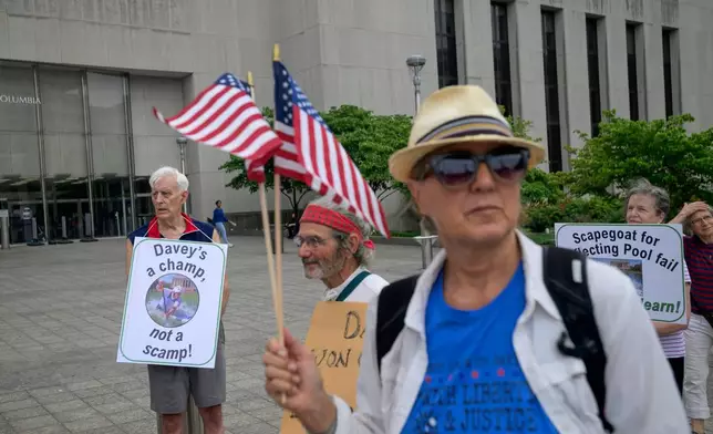 Bill Endicott, former Olympic canoeist David Hearn's coach, left, joins other to rally for Hearn, who was indicted by a grand jury for allegedly damaging the Lincoln Memorial Reflecting Pool, at D.C. Superior Court, Thursday, July 9, 2026, in Washington. (AP Photo/Rod Lamkey, Jr.)