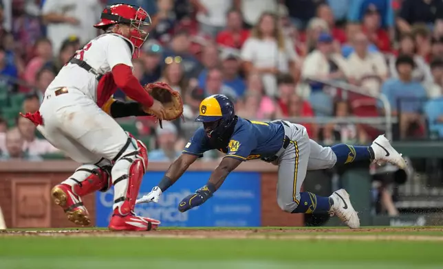 Milwaukee Brewers' Luis Lara, right, scores past St. Louis Cardinals catcher Iván Herrera during the seventh inning in the second game of a baseball doubleheader Tuesday, July 7, 2026, in St. Louis. (AP Photo/Jeff Roberson)