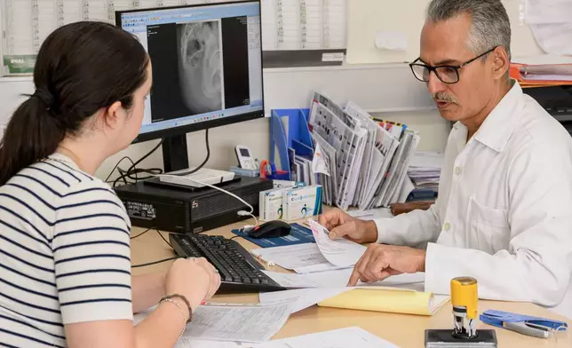 Cuban doctor Raciel Escalona Zaldivar, right, talks to a patient in an orthopedic unit of the Santa Maria degli Ungheresi Hospital of Polistena in the southern Italian Calabria region, June 16, 2026. (AP Photo/Valeria Ferraro)