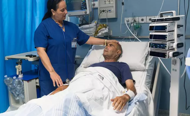 Cuban doctor Daysi Luperon Loforte talks with Teodoro Crea, a patient hospitalized in the emergency unit of the Santa Maria degli Ungheresi Hospital of Polistena, in the southern Italian Calabria region, June 16, 2026. (AP Photo/Valeria Ferraro)