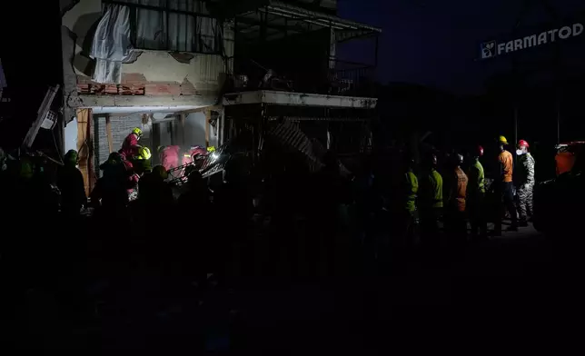Rescuers from Argentina search a building damaged by back-to-back earthquakes after residents reported hearing noises from beneath the rubble in Catia La Mar, Venezuela, Wednesday, July 1, 2026. (AP Photo/Fernando Vergara)