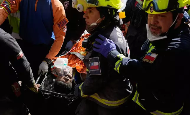 Chilean rescue workers carry Hernán Alberto Gil Flores after he was pulled from the rubble eight days after he was trapped by twin earthquakes that struck Catia La Mar, Venezuela, Thursday, July 2, 2026. (AP Photo/Fernando Vergara)