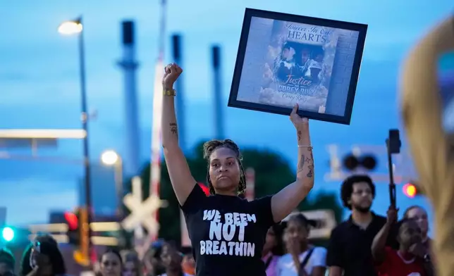 A protester holds a photo of Corey Durell Ruiz as they march Thursday, July 23, 2026, in Madison, Wis., after he was shot and killed by a Madison police officer on Wednesday. (AP Photo/Kayla Wolf)