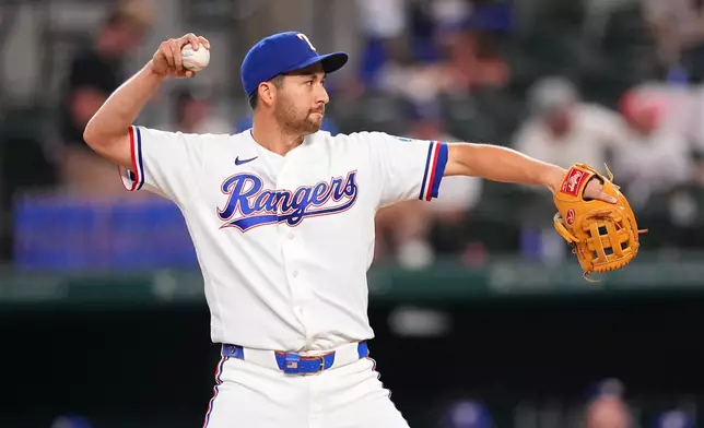 Texas Rangers position player Kyle Higashioka pitches to the Los Angeles Angels during the ninth inning of a baseball game, Wednesday, July 8, 2026, in Arlington, Texas. (AP Photo/Julio Cortez)