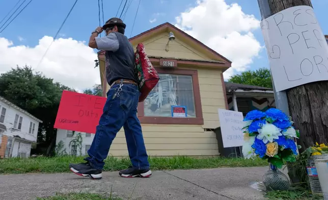 A man walks past a makeshift memorial for Lorenzo Salgado Araujo Wednesday, July 8, 2026, in Houston. (AP Photo/David J. Phillip)