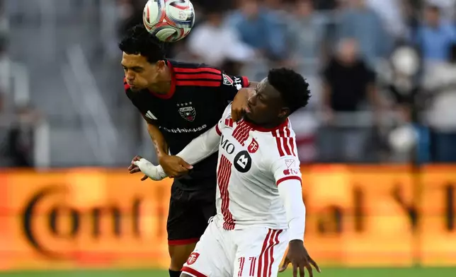 D.C. United midfield Andre Dozzell, left, heads the ball against Toronto FC midfield Derrick Etienne Jr., right, during the first half of an MLS soccer match, Saturday, July 25, 2026, in Washington. (AP Photo/John McDonnell)