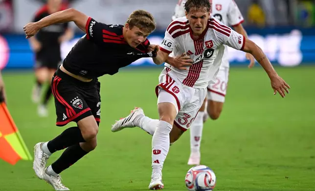 D.C. United midfield Jackson Hopkins, left, and Toronto FC defense Jackson Gilman, right, compete for the ball during the first half of an MLS soccer match, Saturday, July 25, 2026, in Washington. (AP Photo/John McDonnell)