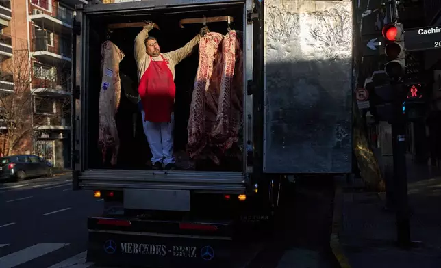 Jose Gomez waits for a coworker to unload beef carcasses at a butcher shop in Buenos Aires, Argentina, Wednesday, July 1, 2026. (AP Photo/Rodrigo Abd)