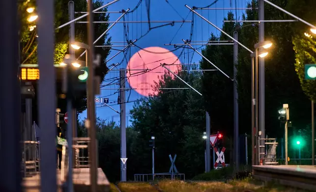 The moon sets behind a subway station in Frankfurt, Germany, Tuesday, June 30, 2026. (AP Photo/Michael Probst)