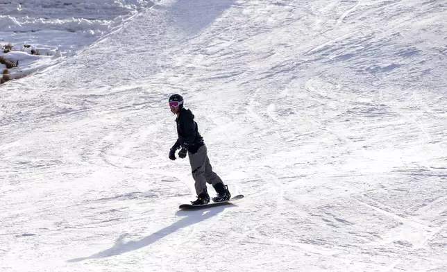 A skier descends carving through the snow at Afriski Mountain Resort in Maluti, Lesotho, Saturday, July 11, 2026. (AP Photo/Kayleen Morgan)