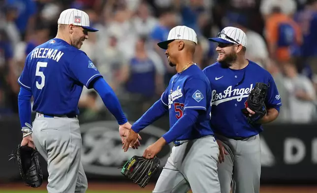 Los Angeles Dodgers' Freddie Freeman (5) celebrates with teammates Mookie Betts (50) and Max Muncy after a baseball game against the New York Mets Saturday, July 25, 2026, in New York. (AP Photo/Frank Franklin II)