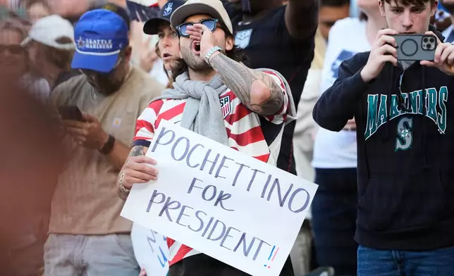 A fan holds a sign for United States men's national soccer team head coach Mauricio Pochettino before a baseball game between the Seattle Mariners and the Toronto Blue Jays, Friday, July 3, 2026, in Seattle. (AP Photo/Lindsey Wasson)