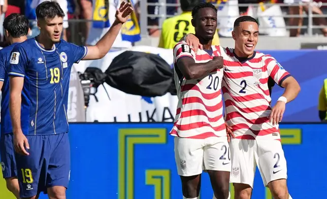 United States' Folarin Balogun (20) celebrates with United States' Sergino Dest (2) after scoring as Bosnia's Kerim Alajbegovic (19) gestures during the World Cup round of 32 soccer match between the United States and Bosnia in Santa Clara, Calif., near San Francisco, Wednesday, July 1, 2026. (AP Photo/Martin Meissner)