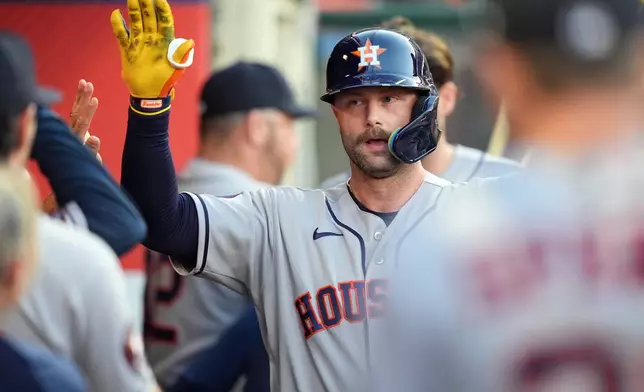 Houston Astros' Christian Walker (8) celebrates with teammates in the dugout after his home run against the Los Angeles Angels during the fourth inning of a baseball game Tuesday, July 28, 2026, in Anaheim, Calif. (AP Photo/Scott Strazzante)