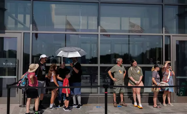 Visitors wait to enter the Washington Monument, Wednesday, July 1, 2026, in Washington. (AP Photo/Tom Brenner)