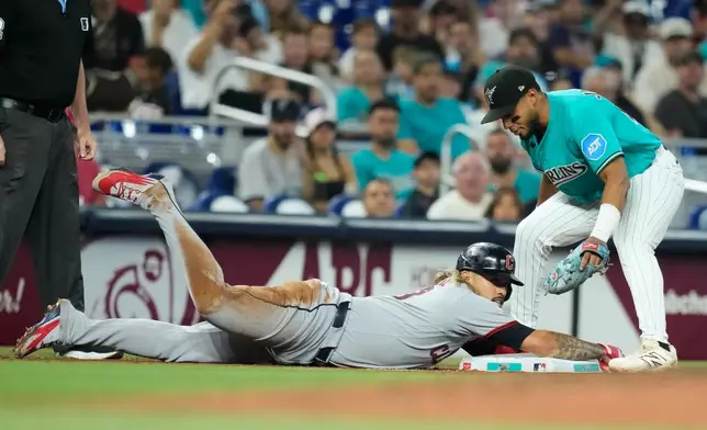 Cleveland Guardians' Gabriel Arias, left, advances to third on a single hit by Steven Kwan during the fourth inning of a baseball game, Sunday, July 12, 2026, in Miami. At right is Miami Marlins third baseman Leo Jiménez. (AP Photo/Lynne Sladky)
