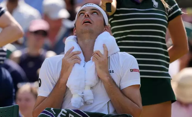 Taylor Fritz of the United States uses ice packs in a towel to cool during the men's singles quarter-final match against Alexander Zverev of Germany at the Wimbledon Tennis Championships in London, Wednesday, July 8, 2026.(AP Photo/Kin Cheung)