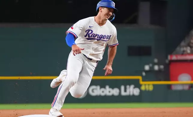 Texas Rangers' Wyatt Langford runs over third base on his way to scoring on a triple by teammate Ezequiel Duran during the first inning of a baseball game against the Seattle Mariners, Saturday, July 25, 2026, in Arlington, Texas. (AP Photo/LM Otero)