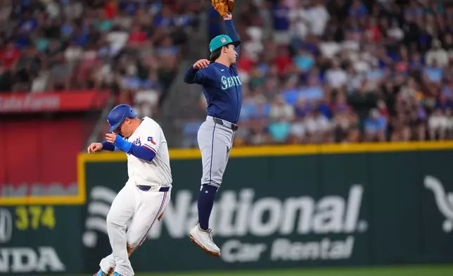 Texas Rangers' Joc Pederson, left, steals second base against Seattle Mariners second baseman Cole Young during the second inning of a baseball game, Saturday, July 25, 2026, in Arlington, Texas. (AP Photo/LM Otero)