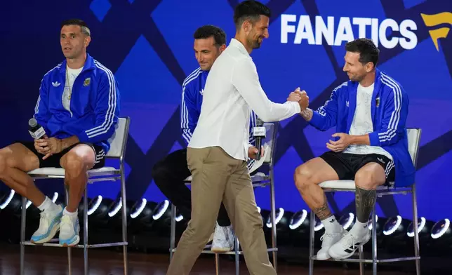 Tennis player Novak Djokovic greets Argentina's Lionel Messi as goalkeeper Emiliano Martinez, left, and head coach Lionel Scaloni look on during a news conference ahead of the World Cup final soccer match between Spain and Argentina in New York, Friday, July 17, 2026. (AP Photo/Stephanie Scarbrough)