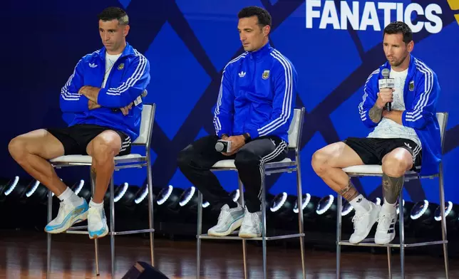 From left, Argentina goalkeeper Emiliano Martinez and head coach Lionel Scaloni listen as Lionel Messi speaks during a news conference ahead of the World Cup final soccer match between Spain and Argentina in New York, Friday, July 17, 2026. (AP Photo/Stephanie Scarbrough)