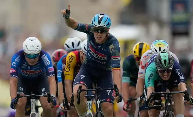 Belgium's Tim Merlier celebrates as he crosses the finish line to win the twelfth stage of the Tour de France cycling race with start in Circuit Nevers Magny-Cours and finish in Chalon-sur-Saone, France, Thursday, July 16, 2026. (AP Photo/Mosa'ab Elshamy)