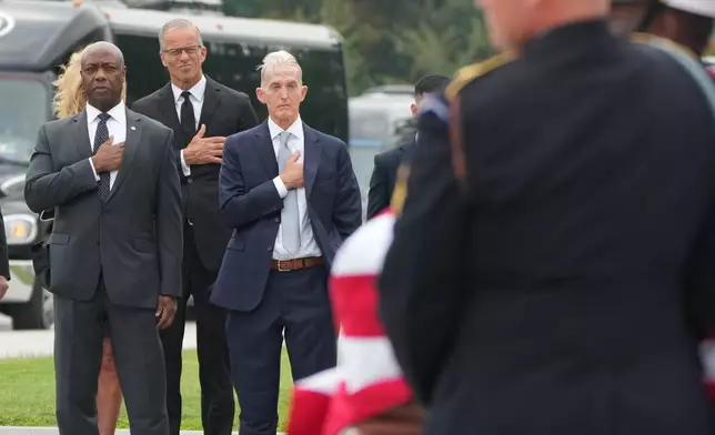Sen. Tim Scott, R-S.C., Senate Majority Leader John Thune, R-S.D., and former Rep. Trey Gowdy, R-S.C., watch as an Armed Forces Body Bearer Team moves the casket of Sen. Lindsey Graham, R-S.C., from the U.S. Capitol after a congressional tribute in the Rotunda Tuesday, July 28, 2026, in Washington. (AP Photo/Mark Schiefelbein, Pool)