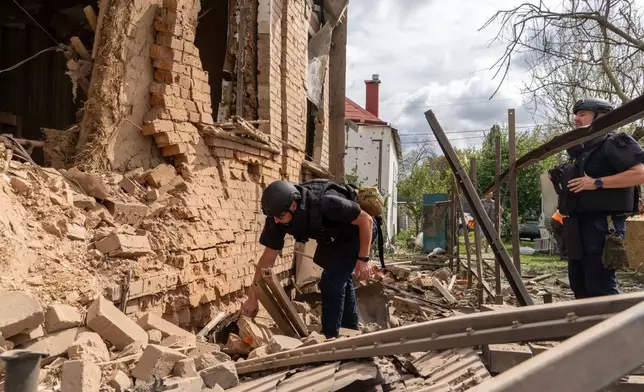 Rescuers search through the rubble of a private house destroyed by a Russian drone in Kharkiv, Ukraine, Sunday, July 26, 2026. (AP Photo/Andrii Marienko)