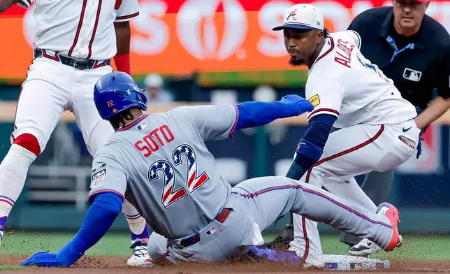 Atlanta Braves second baseman Ozzie Albies, front right, tags out New York Mets' Juan Soto (22) to complete a double play during the first inning of a baseball game, Saturday, July 4, 2026, in Atlanta. (AP Photo/Erik S. Lesser)