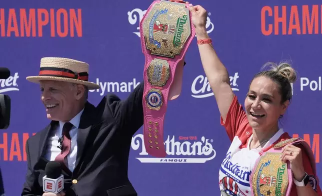 MC George Shea presents competitive eater Miki Sudo with the champion belt after winning the women's 2026 Nathan's Famous Fourth of July hot dog eating contest at Coney Island in the Brooklyn borough of New York, Saturday, July 4, 2026. (AP Photo/Anna Connors)