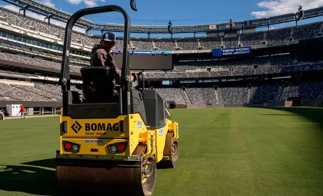FILE - Workers tend to the grass during the pitch installation for FIFA World Cup 2026 at NYNJ Stadium, Thursday, May 7, 2026, in East Rutherford, N.J. (AP Photo/Yuki Iwamura, File)