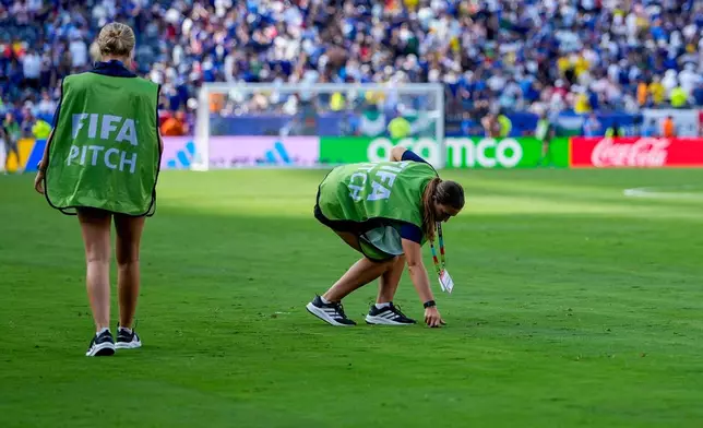 FILE - FIFA Pitch workers repair the grass at halftime during the World Cup round of 32 soccer match between France and Sweden in East Rutherford, N.J., near New York, Tuesday, June 30, 2026. (AP Photo/Frank Franklin II, File)