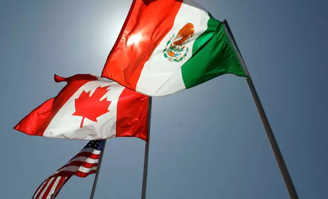 FILE - National flags representing the United States, Canada, and Mexico fly in the breeze in New Orleans where leaders of the North American Free Trade Agreement met on April 21, 2008. (AP Photo/Judi Bottoni, File)