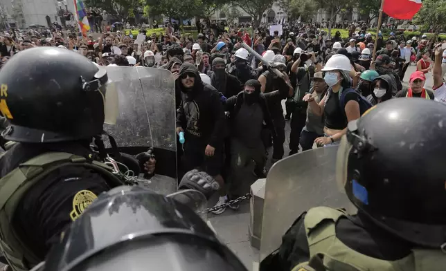 Opponents of Peru's new President Keiko Fujimori confront police during a protest on the day of her inauguration in Lima, Peru, Tuesday, July 28, 2026. (AP Photo/Gerardo Marin)