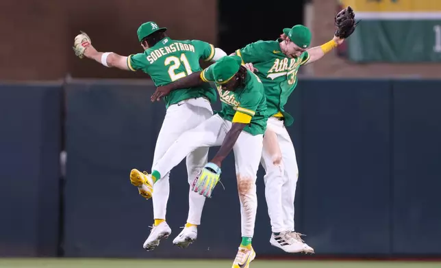 Athletics' Tyler Soderstrom (21), Lawrence Butler, center, and Henry Bolte celebrate the Athletics win over the Boston Red Sox in a baseball game Tuesday, July 28, 2026, in West Sacramento, Calif. (AP Photo/Scott Marshall)