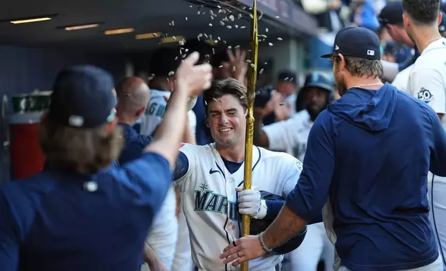 Seattle Mariners relief pitcher Bryce Miller throws seeds at Cole Young as Young celebrates his three-run home run against the San Francisco Giants during the seventh inning of a baseball game, Saturday, July 18, 2026, in Seattle. (AP Photo/Lindsey Wasson)