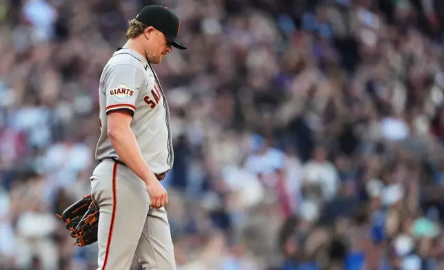 San Francisco Giants starting pitcher Logan Webb reacts to giving up a three-run home run to Seattle Mariners' Cole Young during the seventh inning of a baseball game, Saturday, July 18, 2026, in Seattle. (AP Photo/Lindsey Wasson)