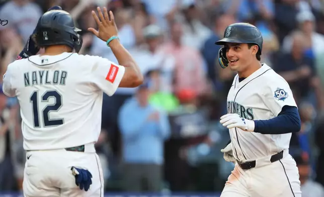 Seattle Mariners' Cole Young, right, is greeted by Josh Naylor (12) after hitting a three-run home run against the San Francisco Giants during the seventh inning of a baseball game, Saturday, July 18, 2026, in Seattle. (AP Photo/Lindsey Wasson)