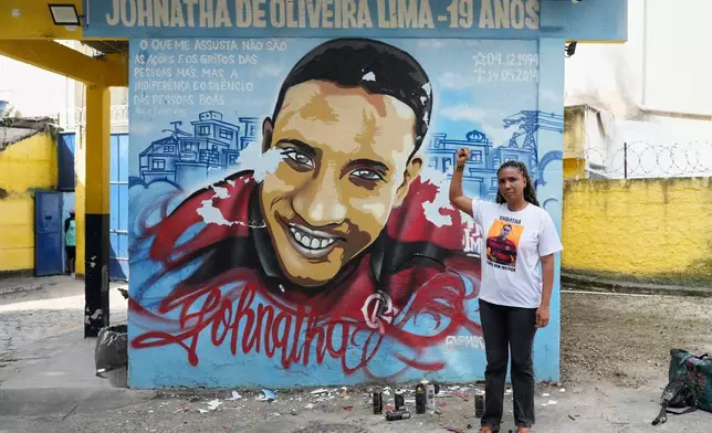 Ana Paula Oliveira poses for a photo by a mural honoring her late son Johnatha, who was killed by police when he was 19, in Rio de Janeiro, Thursday, May 14, 2026. (AP Photo/Silvia Izquierdo)