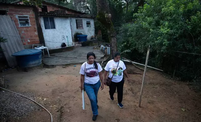 Nadia dos Santos, right, and her sister Glaucia dos Santos, who have sons who were killed by police, walk outside the home where Nadia lived with one of her sons in the Morro da Criança favela in Rio de Janeiro, Thursday, June 4, 2026. Nadia's two sons Cleyton dos Santos Bravo and Cleyverson dos Santos Bravo, and her sister's son Fabricio dos Santos, were killed by police. (AP Photo/Bruna Prado)
