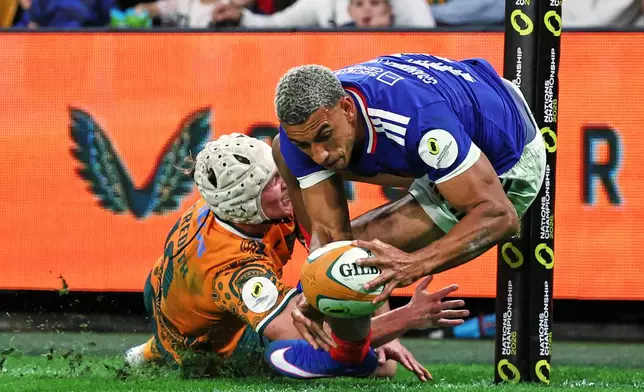 France's Aaron Grandidier-Nkanang scores a try in the tackle of Australia's Declan Meredith during the Nations Championship rugby international between France and Australia in Brisbane, Australia, Saturday, July 11, 2026. (AP Photo/Tertius Pickard)