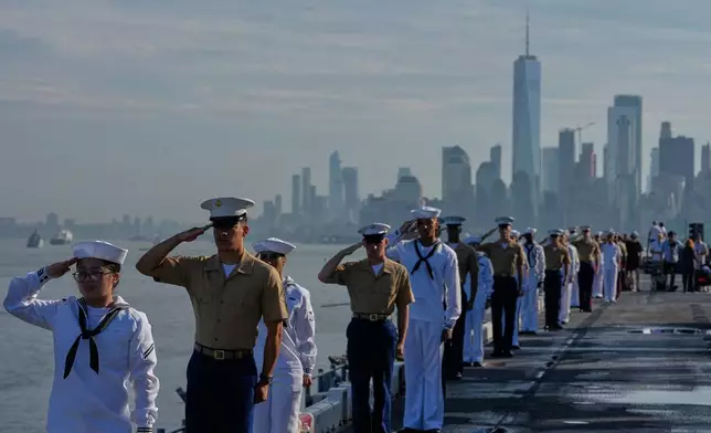 Military personnel salute from the flight deck of the USS Kearsarge (LHD-3) in the New York harbor during The International Naval Review, ahead of Sail250, a gathering of tall ships and military ships honoring America's 250th Anniversary, Saturday, July 4, 2026, in New York. (AP Photo/Frank Franklin II)