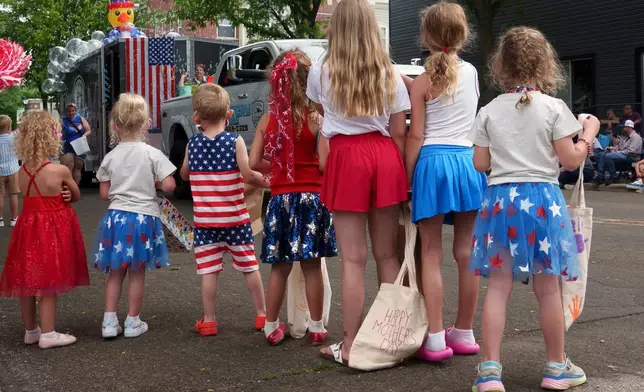 Children line up to watch an Independence Day parade, Saturday, July 4, 2026, in Deforest, Wis. (AP Photo/Jon Elswick)