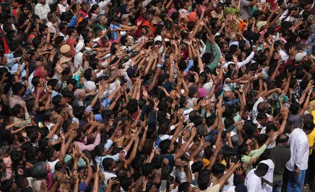 Indian devotees raise their hands to receive offerings as they participate in the annual chariot procession of Hindu deity Lord Jagannath, in Ahmedabad, India, Thursday, July 16, 2026. (AP Photo/Ajit Solanki)