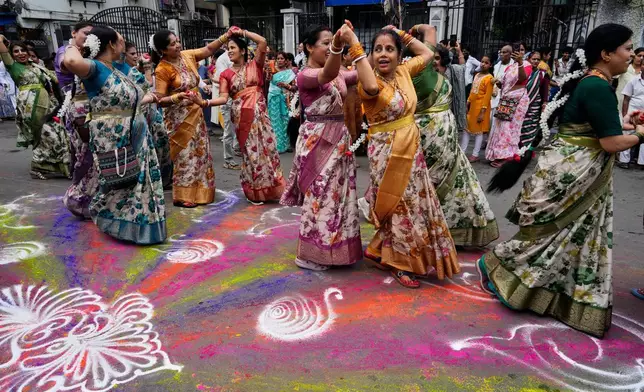 Hindu devotees sing and dance on a street decorated with coloured powder during the Rath Yatra, or chariot festival, carrying the Hindu deities of Jagannath, Balaram and Subhadra, in Kolkata, India, Thursday, July 16, 2026. (AP Photo/Bikas Das)