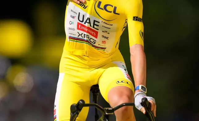 Slovenia's Tadej Pogacar, wearing the overall leader's yellow jersey, celebrates after winning the tenth stage of the Tour de France cycling race with start in Aurillac and finish in Le Lioran, France, Tuesday, July 14, 2026. (AP Photo/Mosa'ab Elshamy)