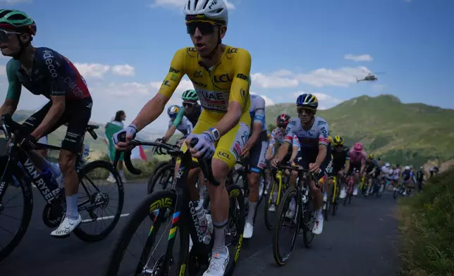 Slovenia's Tadej Pogacar, wearing the overall leader's yellow jersey, rides in the pack during the tenth stage of the Tour de France cycling race with start in Aurillac and finish in Le Lioran, France, Tuesday, July 14, 2026. (AP Photo/Thibault Camus)