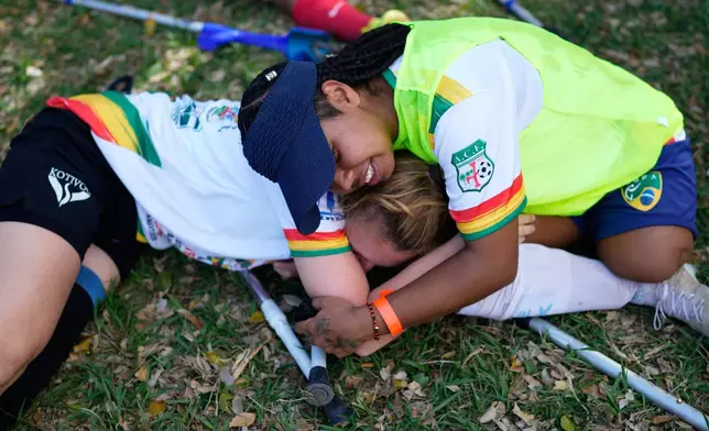 Players hug each other after playing during a women's amputee soccer clinic in Santa Cruz, Bolivia, Friday, July 17, 2026. (AP Photo/Juan Karita)